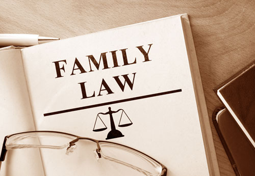 A sepia-toned open book titled "FAMILY LAW" with scales icon and eyeglasses.